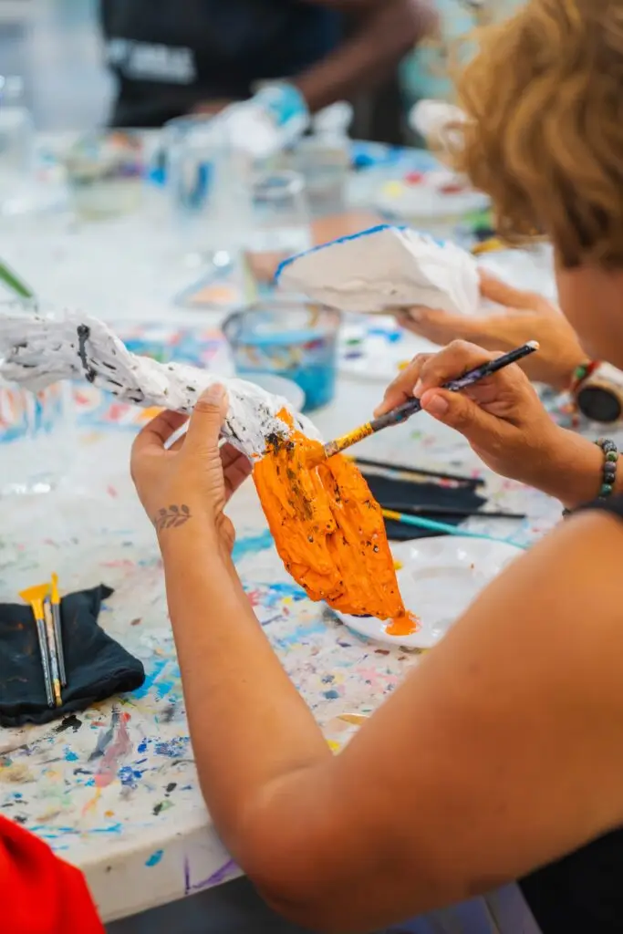 Close-up of hands painting with a brush at the fair workshop
